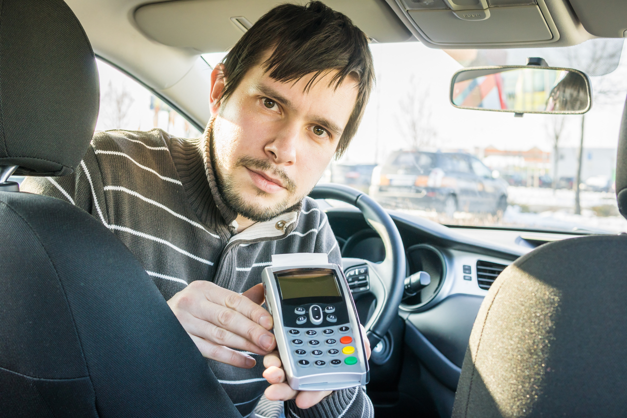 Image: Man ready to accept card payment in a car