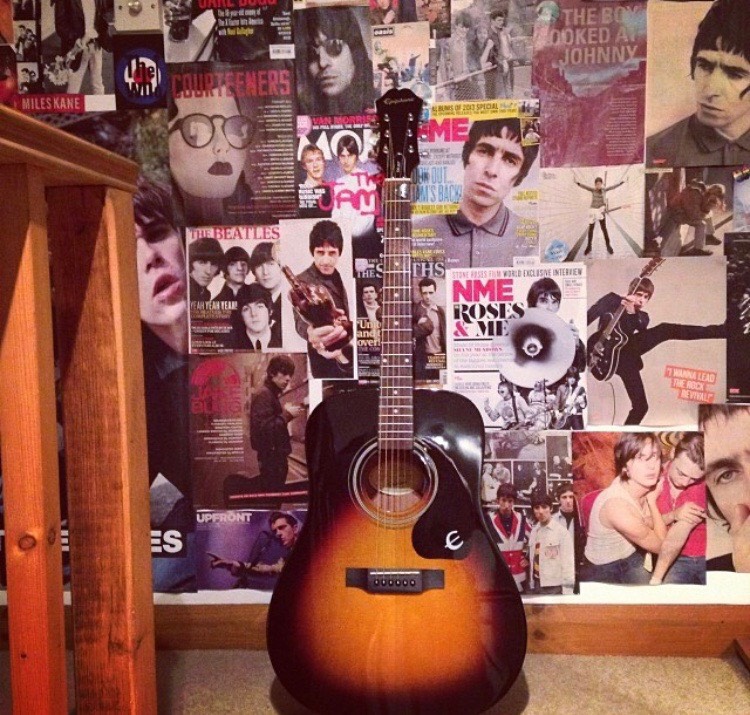 Image: Guitar against wall covered in NME magazine cut-outs indie/alternative music