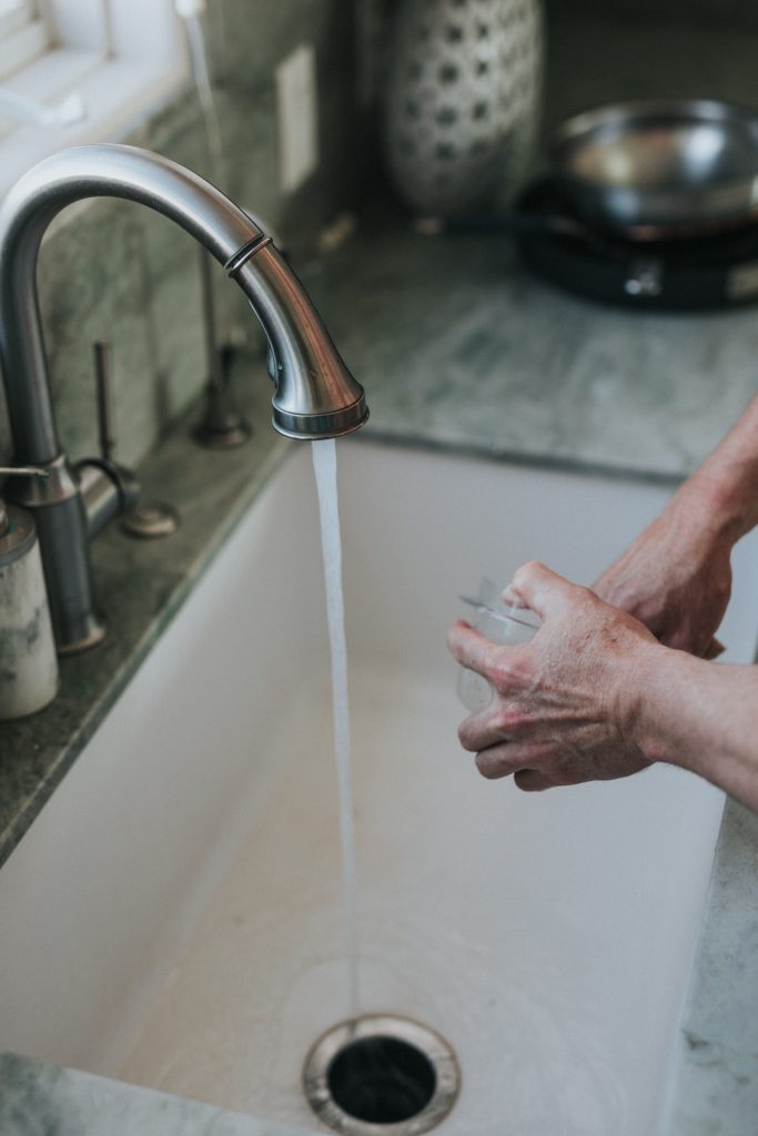 photo of a hand washing a bowl in the sink