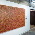 Photograph of abstract artwork comprising of yellow and red shapes and lines.