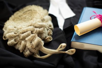 Barrister wig and gown, with book and scroll.