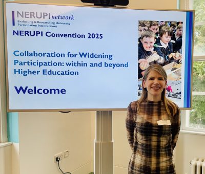 Fleur Middlebrough, of Salford Business School standing in front of a projector with a presentation bout widening participation on it.