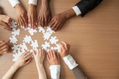 A group of hands moving puzzle pieces
