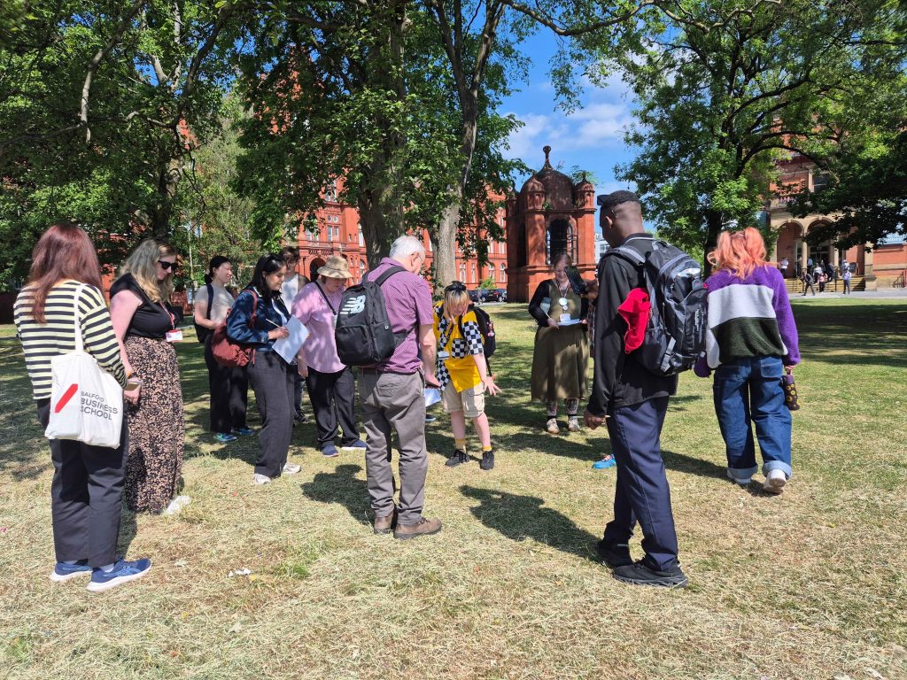 People stood on grass with a member of the Sustainability Team pointing towards the ground.