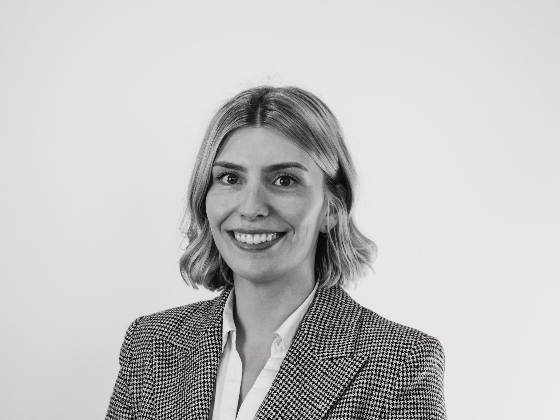 A picture of Rebecca smiling with a plain background.