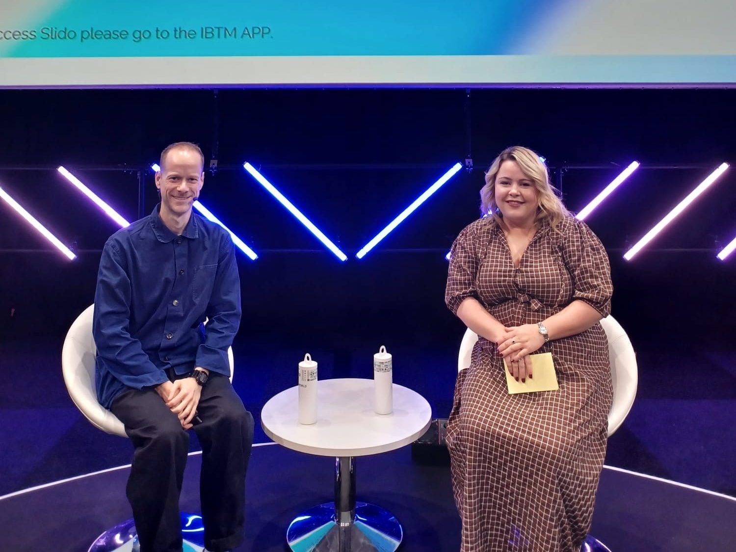 Richard and somebody else sat on a stage with a screen behind them that has the title "Purpose-Driven Events: Why Social Impact is Non-Negotiable"