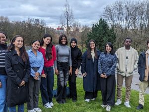 A group of people standing outside on campus smiling.