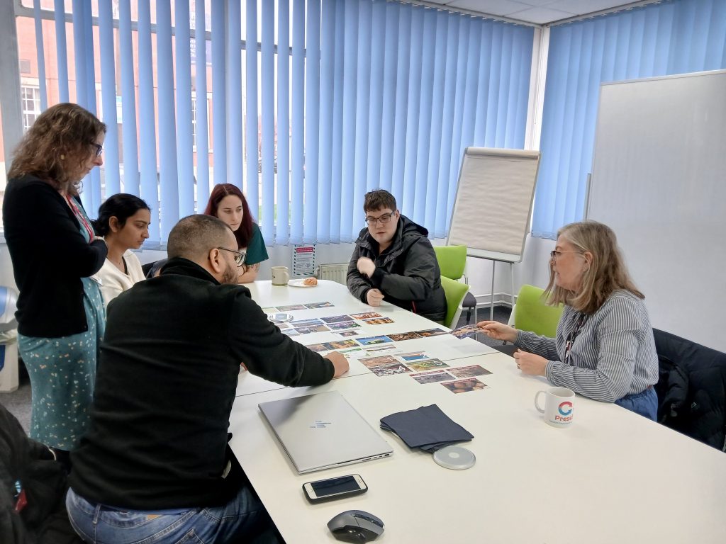 People sat around a table doing a collage.