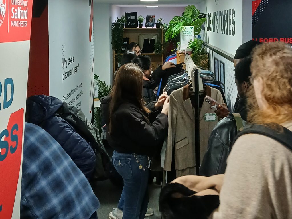 People choosing items from a clothing rail.