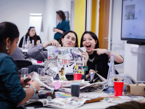 Students creating a collage from recycled newspapers and magazines during a workshop.