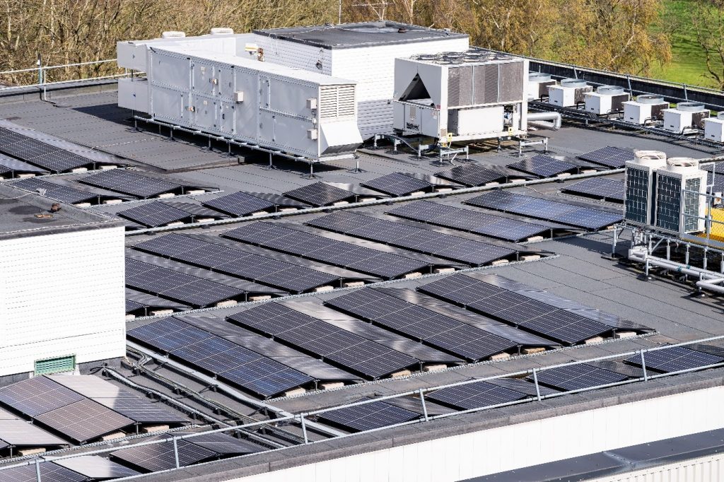 Rooftop solar panels installed alongside ventilation and air-conditioning equipment on a commercial building