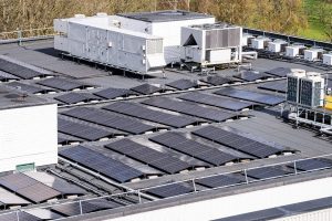 Rooftop solar panels installed alongside ventilation and air-conditioning equipment on a commercial building