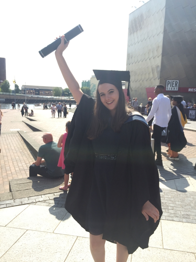 Holly graduating and holding up her diploma