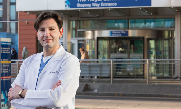 Alex Woodman outside The Royal Oldham Hospital in a lab-coat