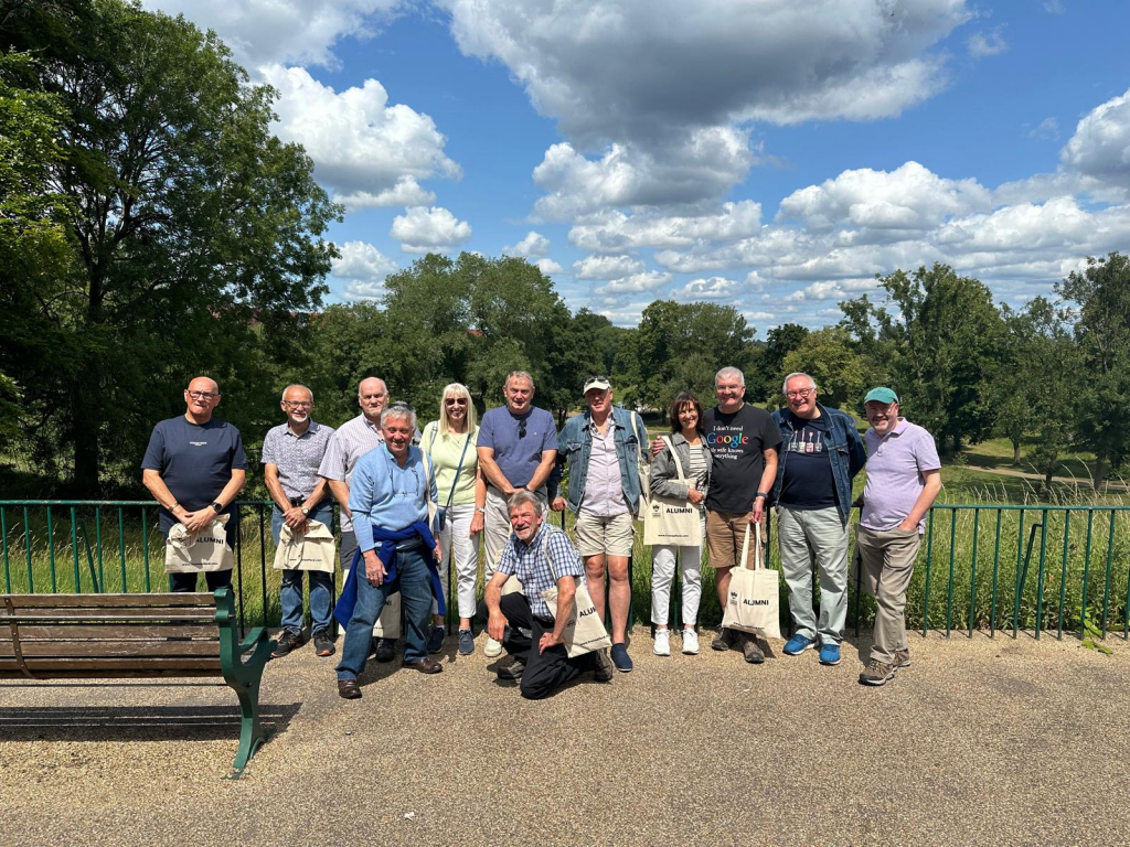 The group of alumni posing for a photograph overlooking Peel Park