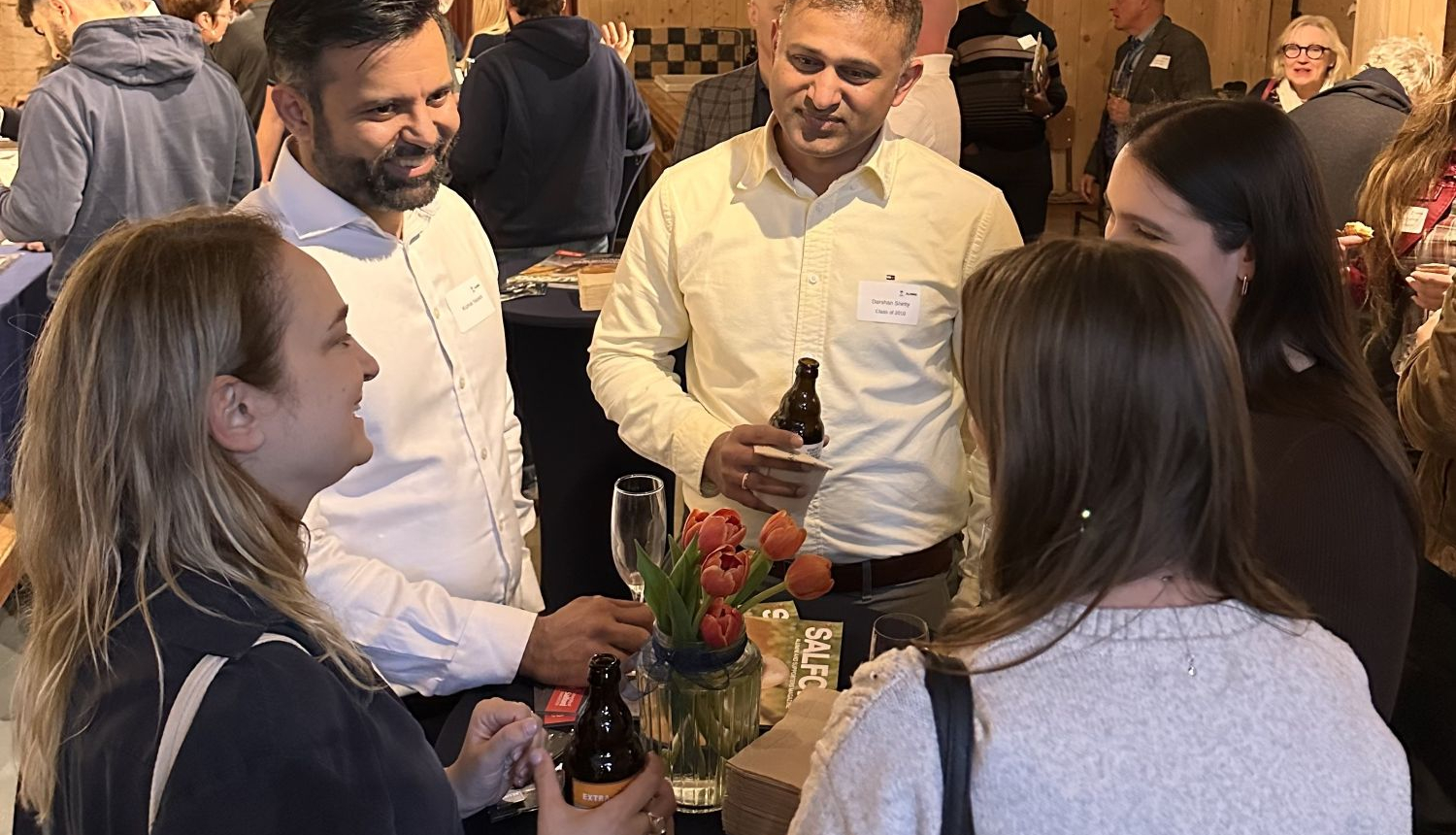 A group of alumni networking at the social event