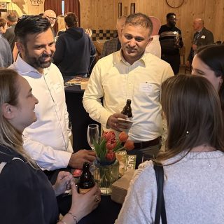 A group of alumni networking at the social event
