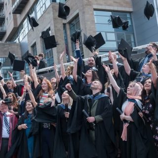 students throwing caps in the air for graduation