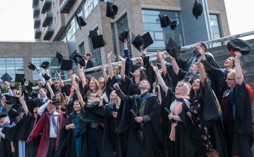 students throwing caps in the air for graduation