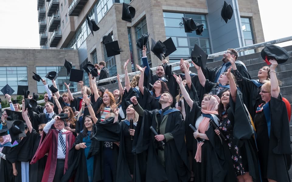 students throwing caps in the air for graduation