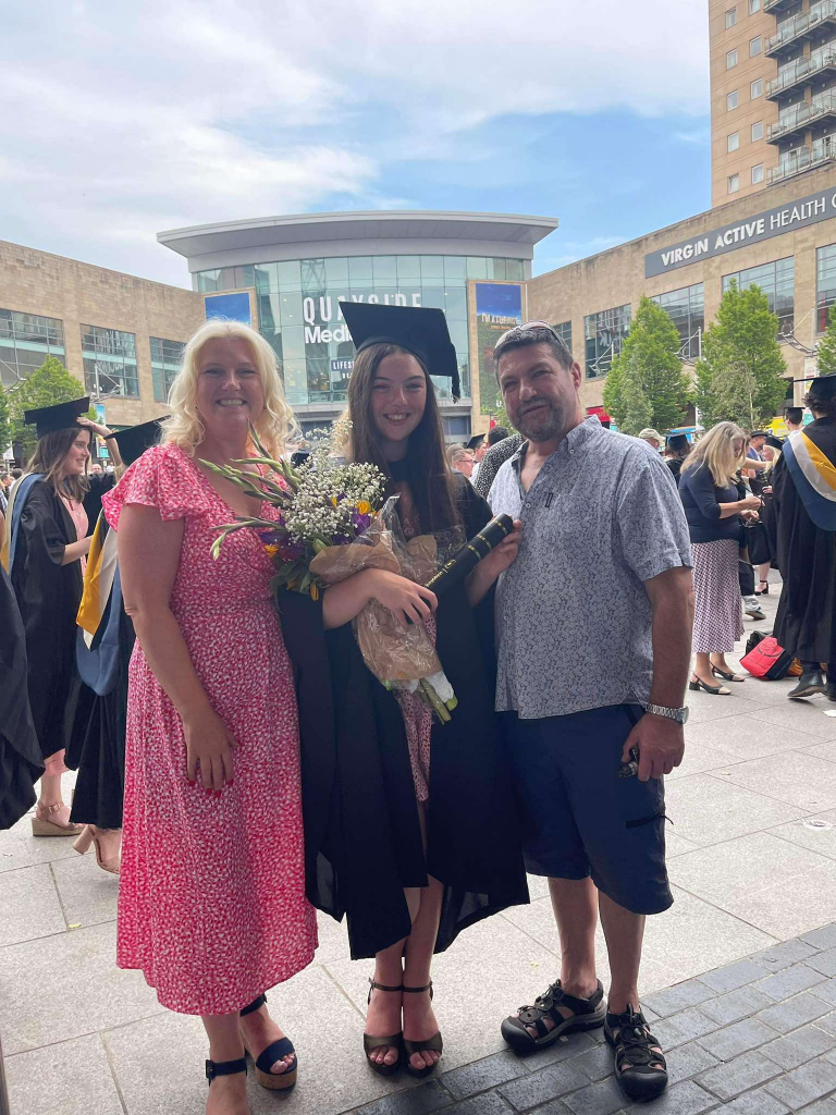 Athina and her proud parents celebrate graduation in 2022