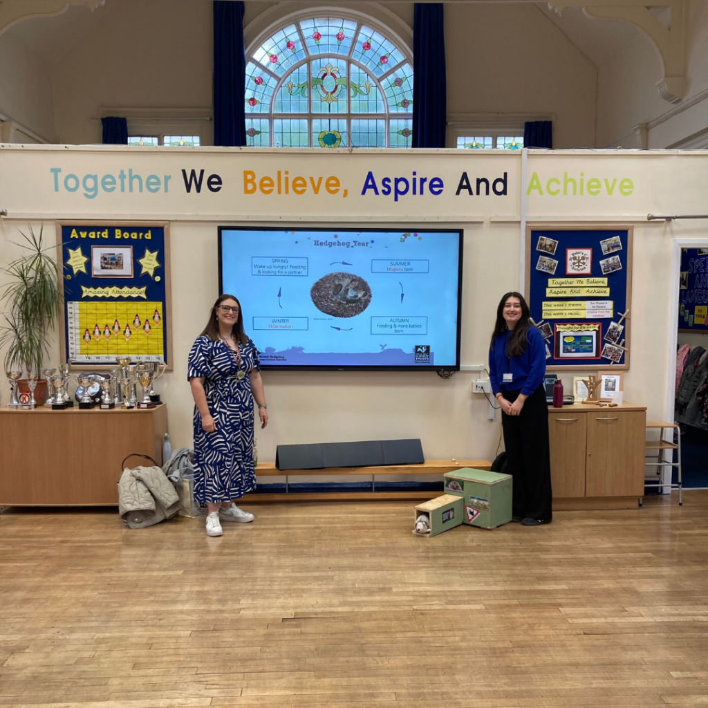 Two members of staff from the Sustainability Office in an assembly hall.