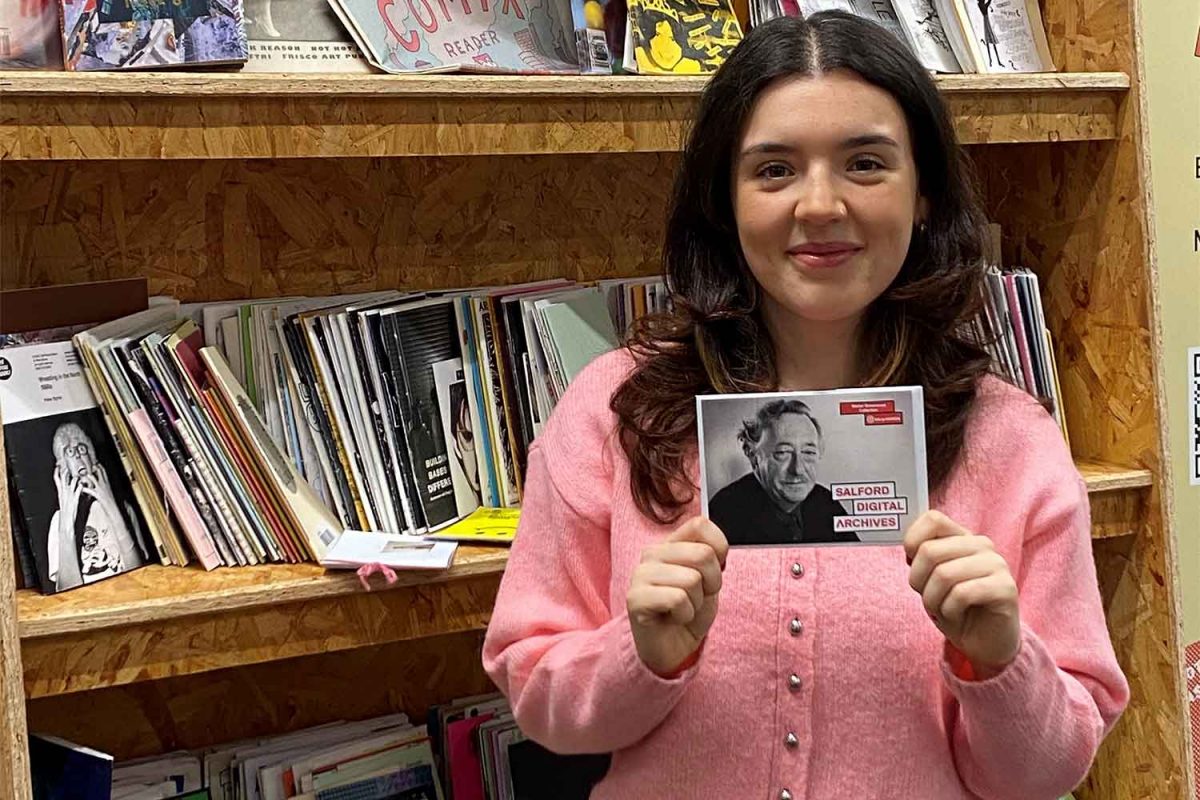 A student holds a photo of Walter Greenwood