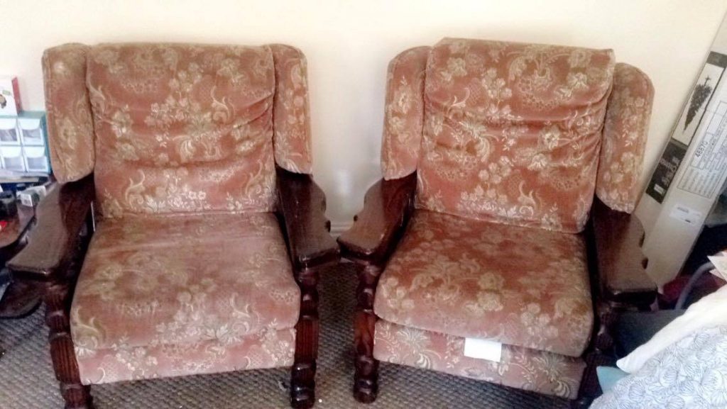2 light red armchairs with wooden legs and arms