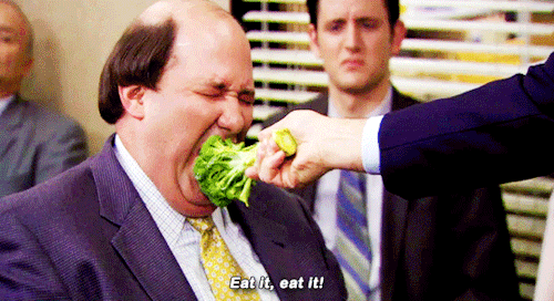 man being fed broccoli