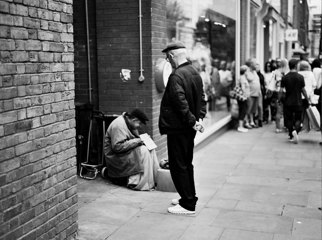 Image: Man looking at homeless man