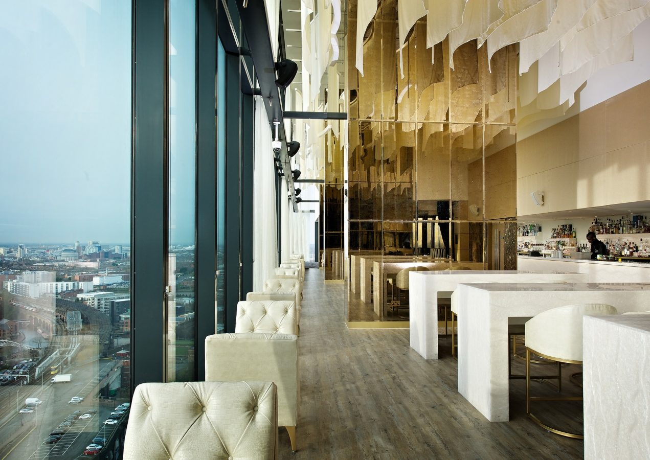 Inside Cloud 23 showing view outside through window on the left and white tables and chairs on the right inside the restaurant