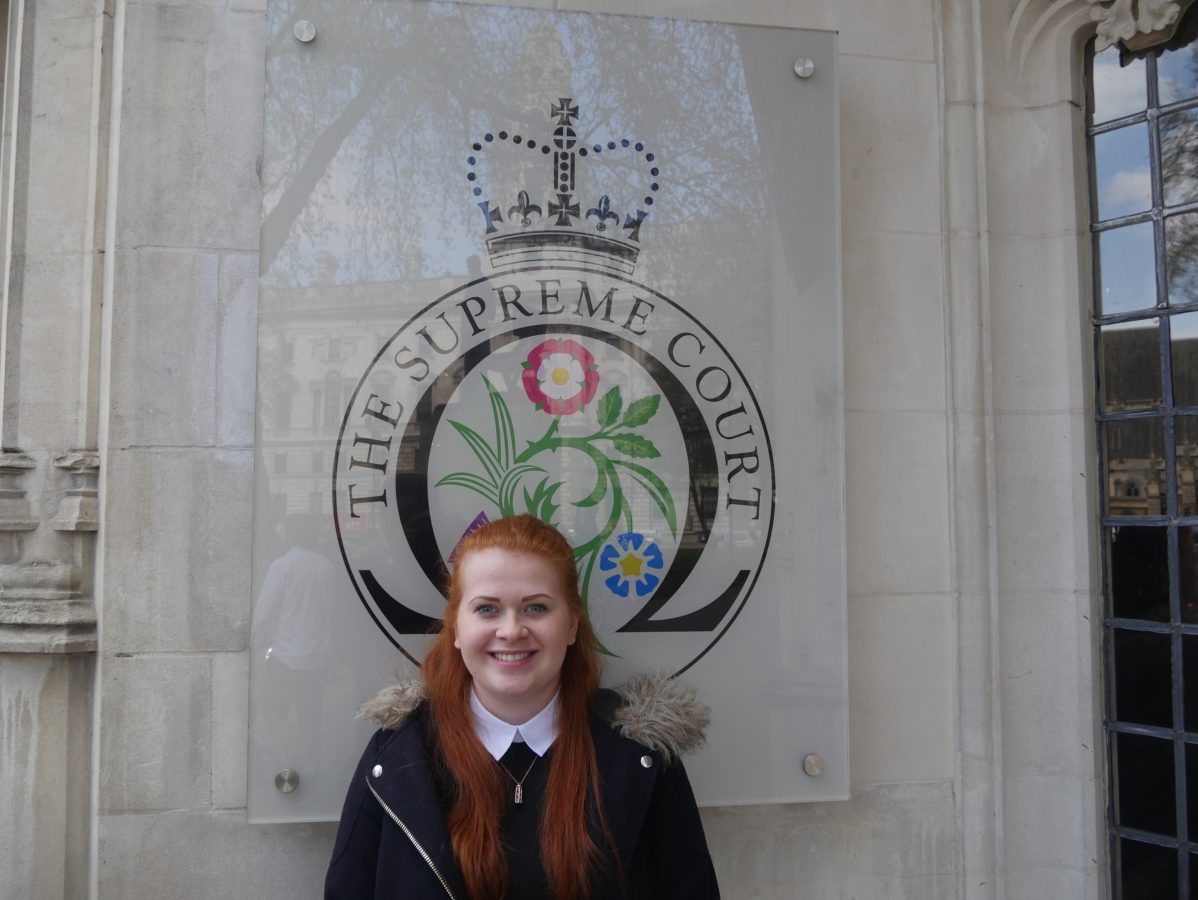 Kimberley Jones in front of the Supreme Court logo on a wall