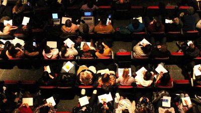 Birdseye view image of students making notes at the conference