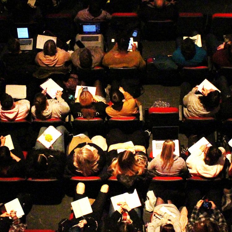 Birdseye view image of students making notes at the conference