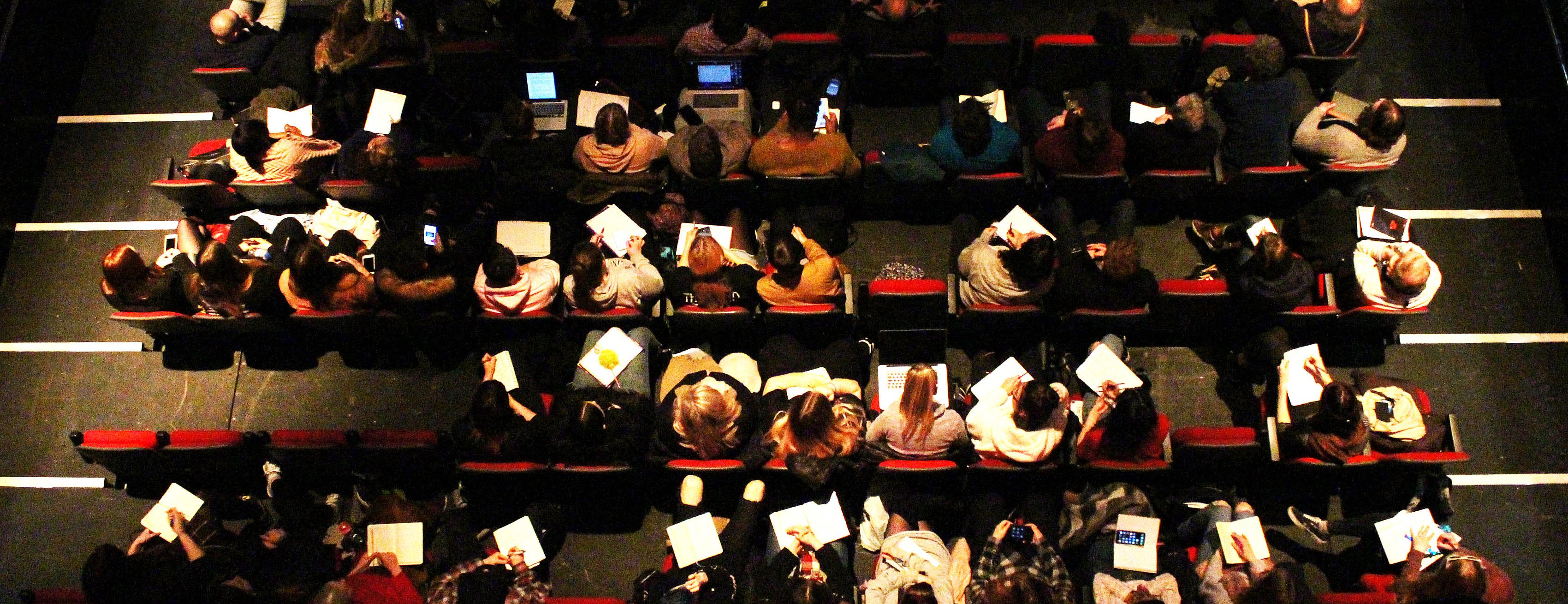 Birdseye view image of students making notes at the conference