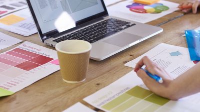 image: Close Up Of Designers Discussing Layouts And Color Schemes