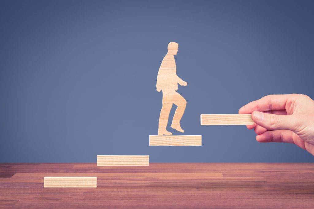 Image: a man is walking up the steps resembling achievement for the future 