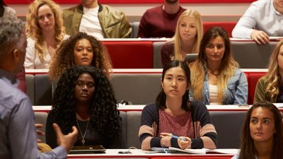 image: lecturer giving a lesson to a group of students