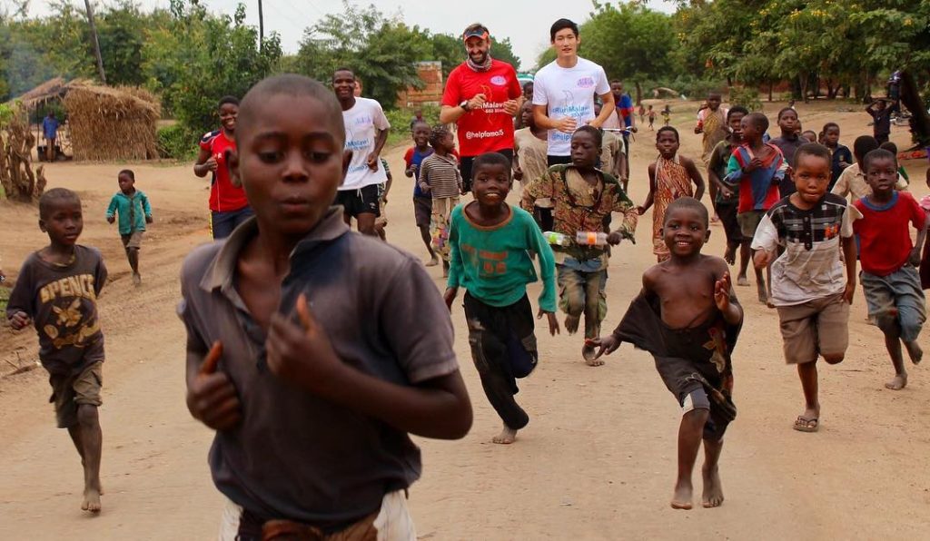 Salford graduate Brendan Rendall running with children of Malawi