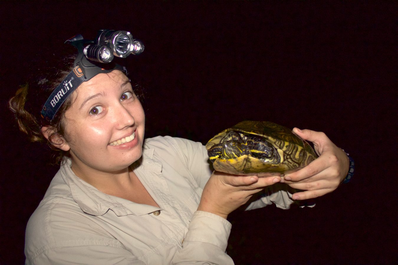 Student Evie holding a turtle at night time