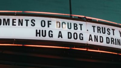 Old fashioned theatre sign reading: In moments of doubt, trust your gut, hug a dog and drink gin