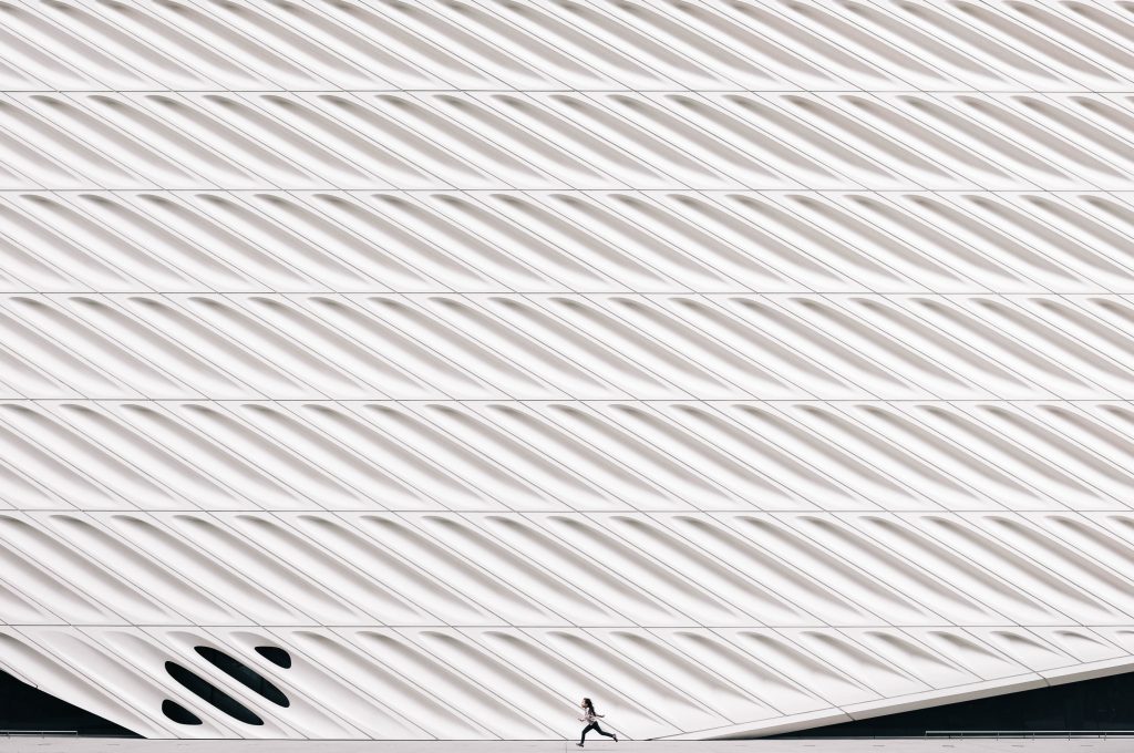 a tall wall with a little girl running past