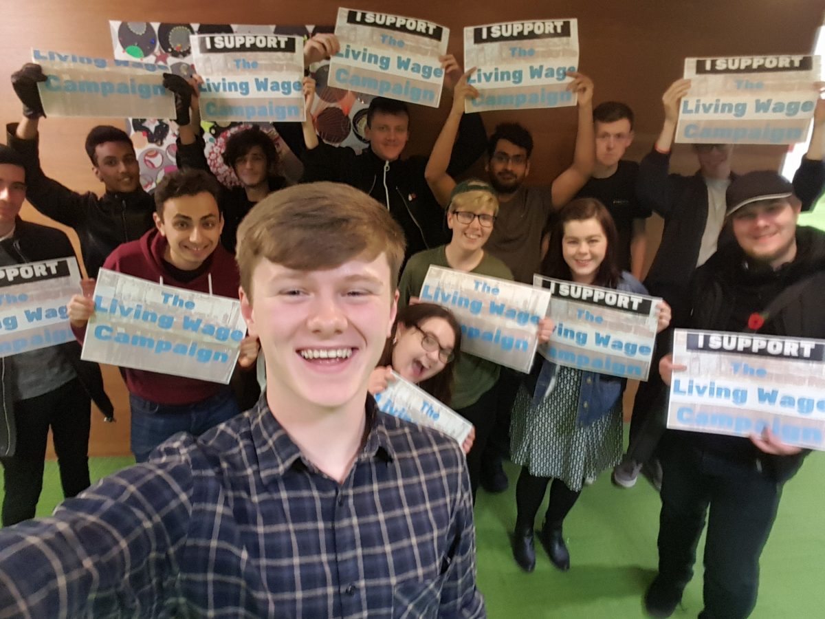 Jon-Connor with other students holding Living Wage boards