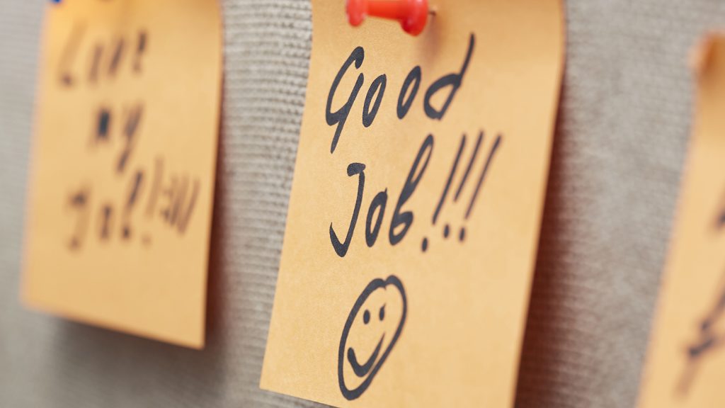 The words 'Good Job' with a smiley face underneath wrote on a Postit note