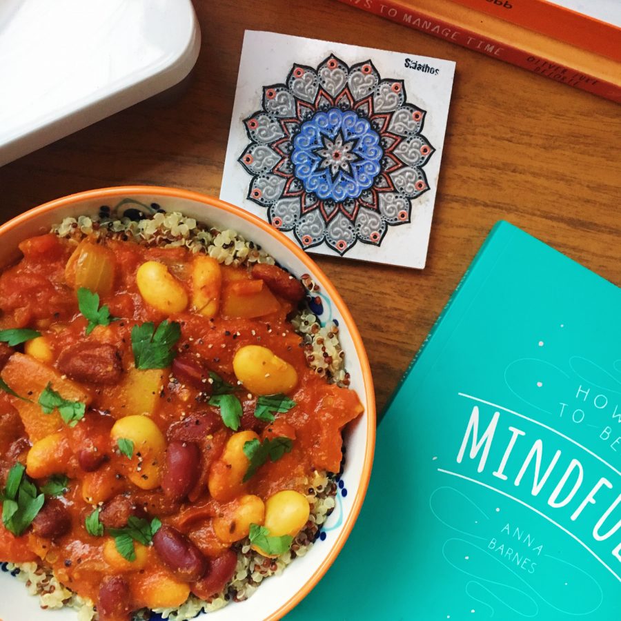 Vegetable chilli in a bowl next to a book on Mindfulness