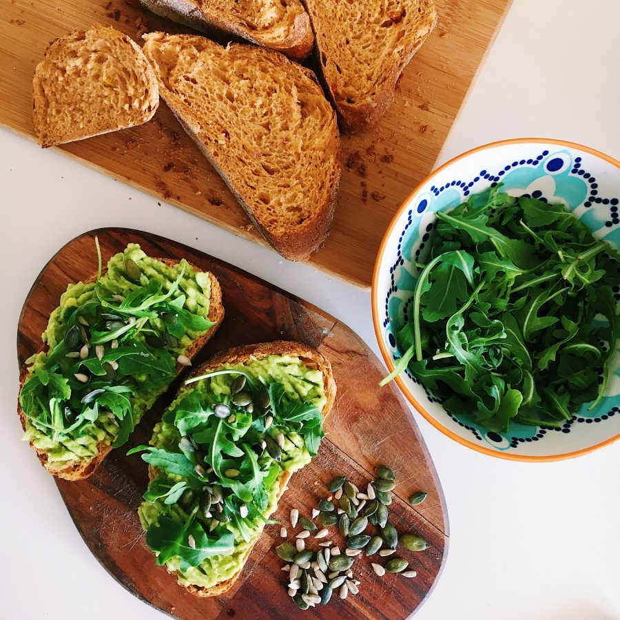Avocado on toast garnished with rocket leaves
