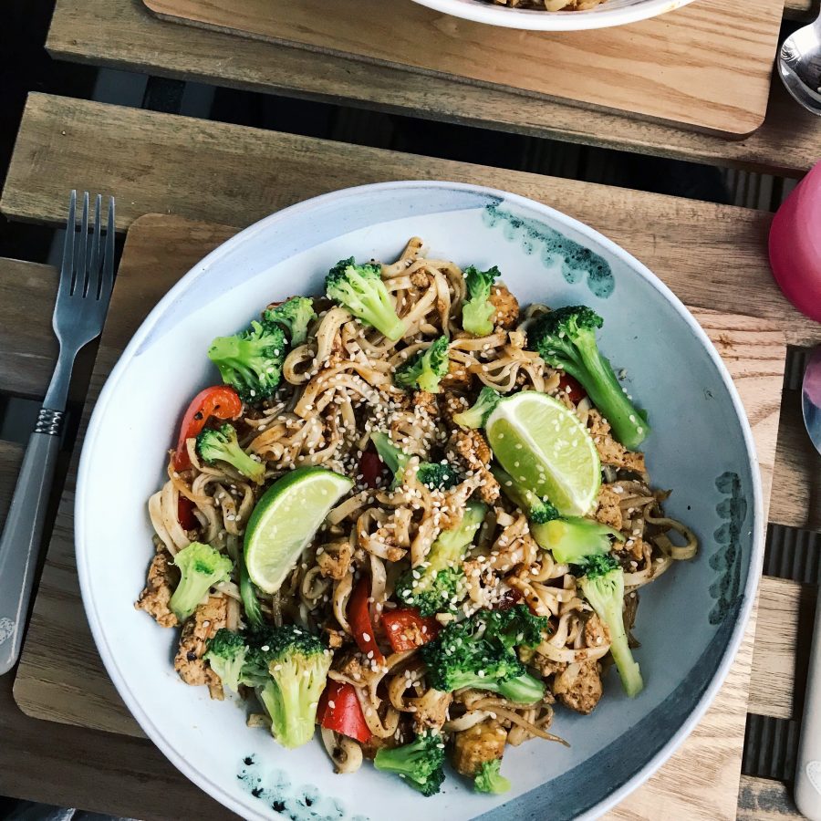 Stir fry in a white bowl on a table outside