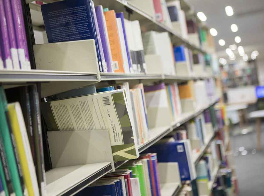 A close up of some of the books on shelves in the Clifford Whitworth Library