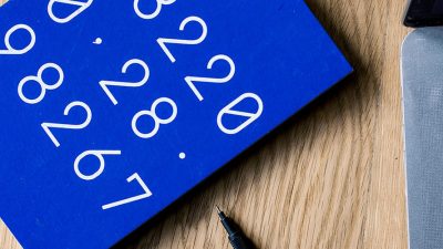 An up close shot of a laptop and a blue notebook