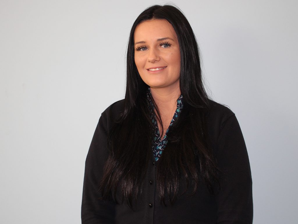 A photo of Laura Billington smiling after pitching for the Dragon's Den panel. She has long black hair and is wearing a black cardigan.